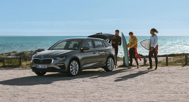  Drei Sportler packen ihre Surfboards in den Skoda.